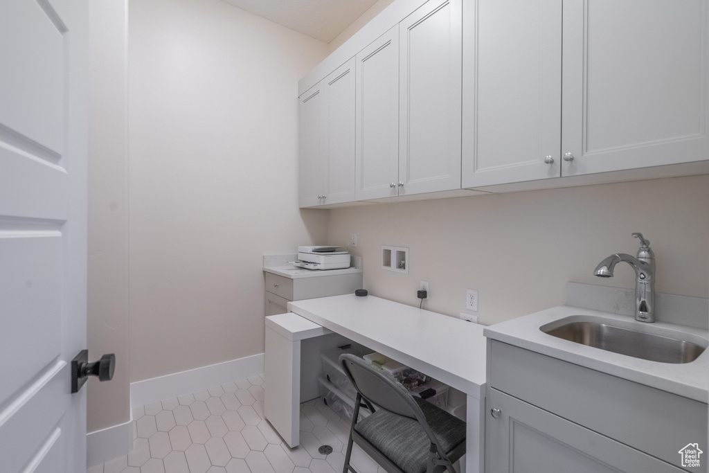 Laundry area featuring hookup for an electric dryer, cabinets, light tile flooring, washer hookup, and sink