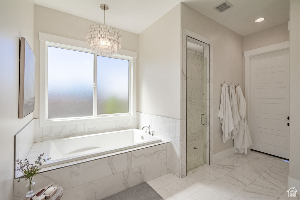 Bathroom featuring plus walk in shower, a notable chandelier, and tile flooring