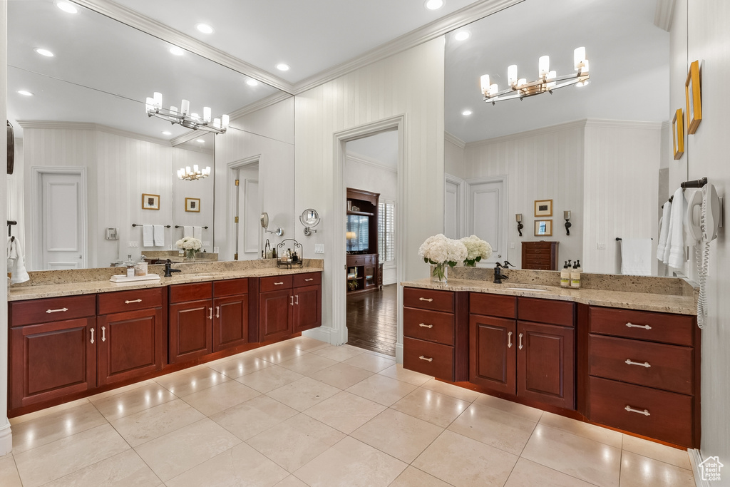 Bathroom with ornamental molding, tile floors, vanity, and a notable chandelier
