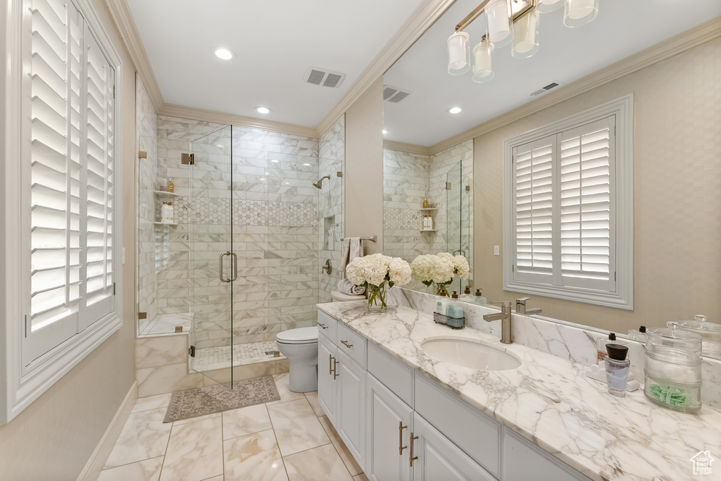 Bathroom featuring ornamental molding, toilet, tile flooring, and vanity with extensive cabinet space