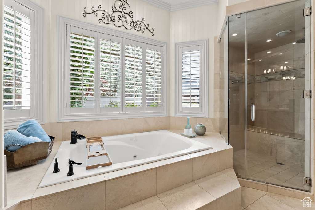 Bathroom featuring a wealth of natural light, ornamental molding, tile floors, and separate shower and tub