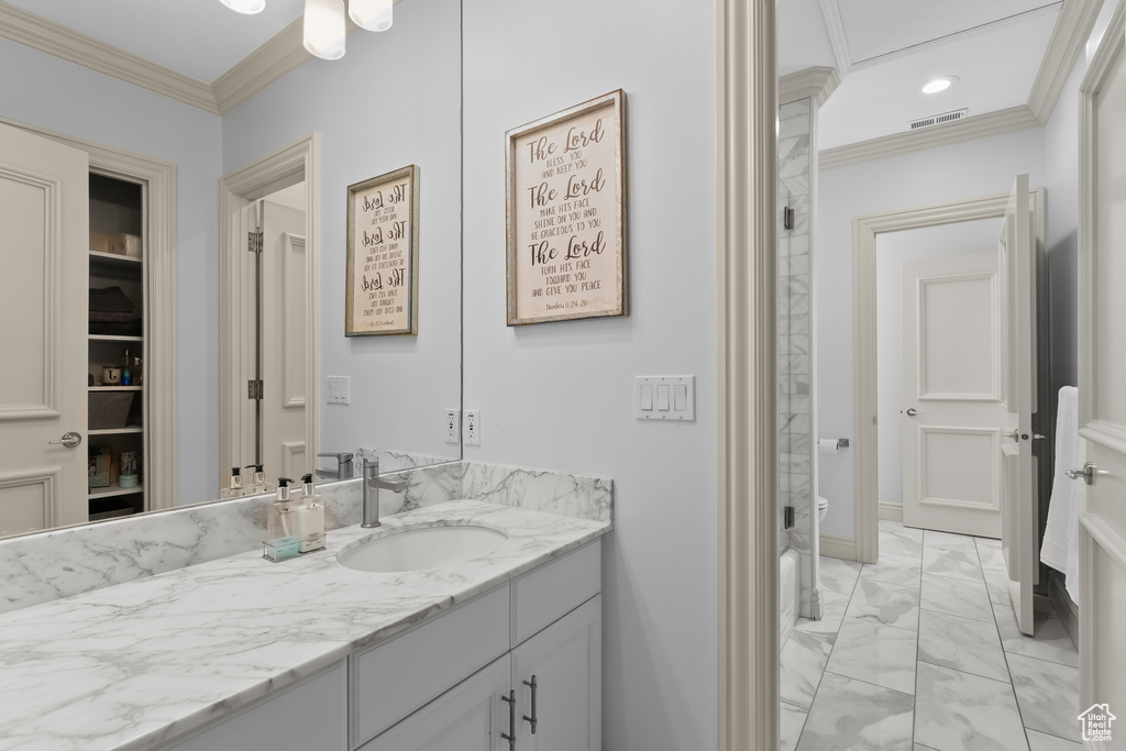 Bathroom featuring vanity, crown molding, and tile flooring