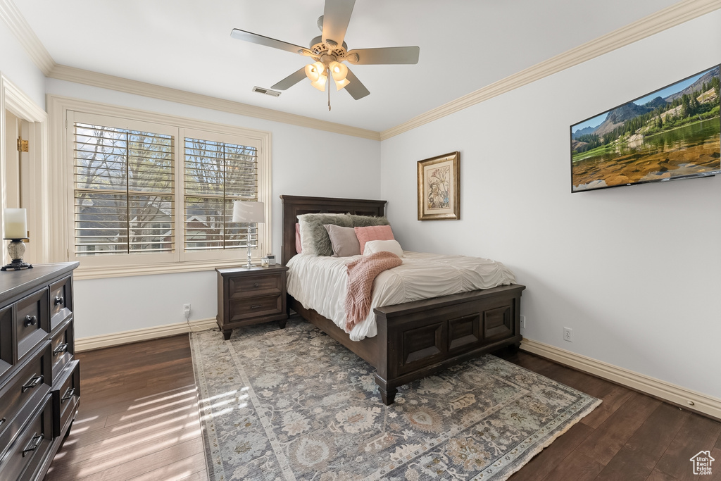Bedroom with hardwood / wood-style flooring, crown molding, and ceiling fan
