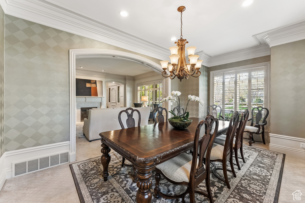 Dining area with crown molding and a chandelier