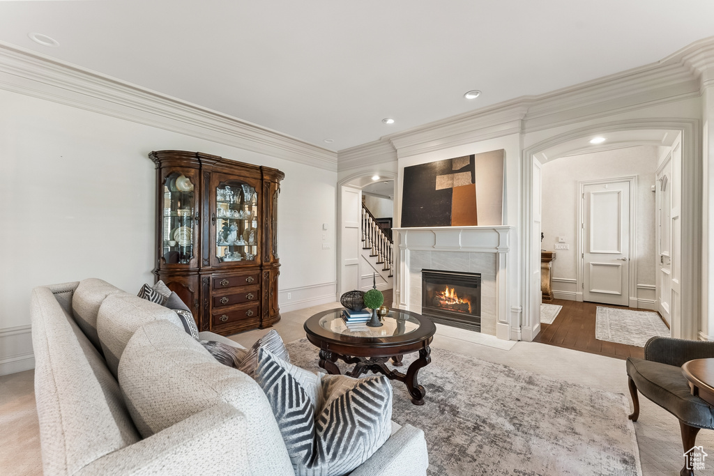Living room with hardwood / wood-style flooring, crown molding, and a fireplace