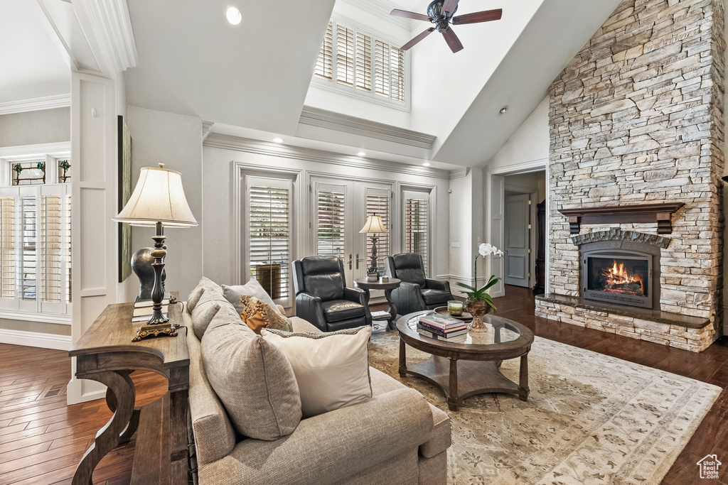 Living room featuring high vaulted ceiling, a fireplace, hardwood / wood-style floors, and ceiling fan