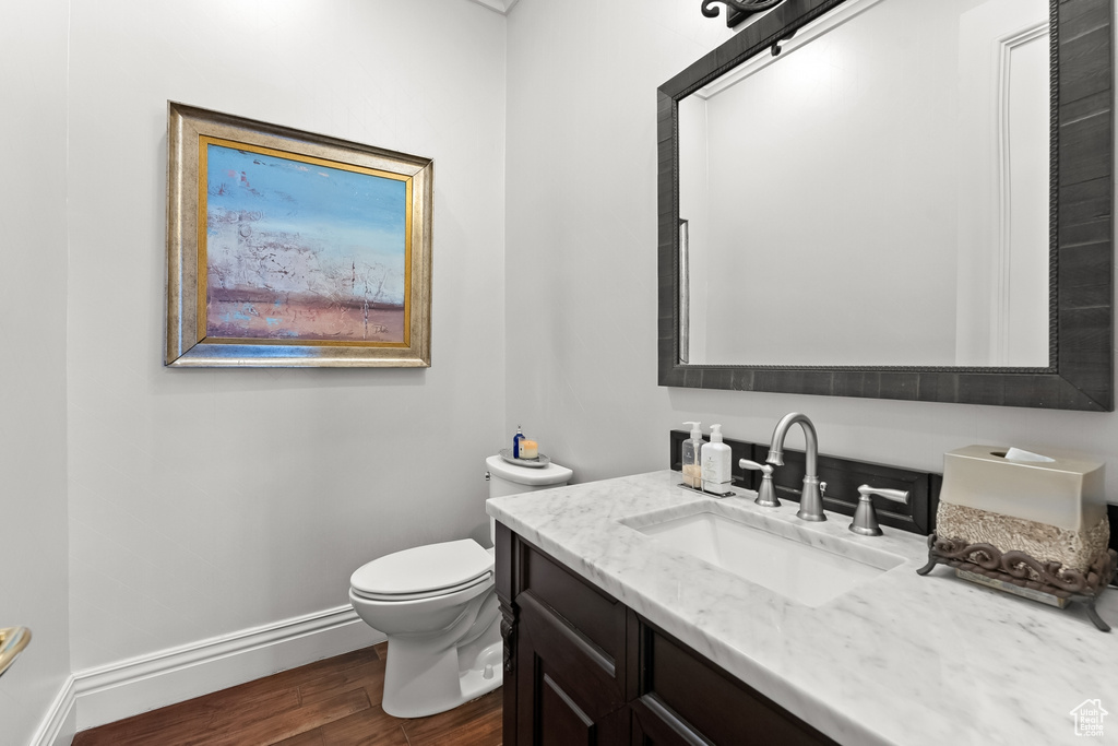 Bathroom featuring large vanity, hardwood / wood-style flooring, and toilet
