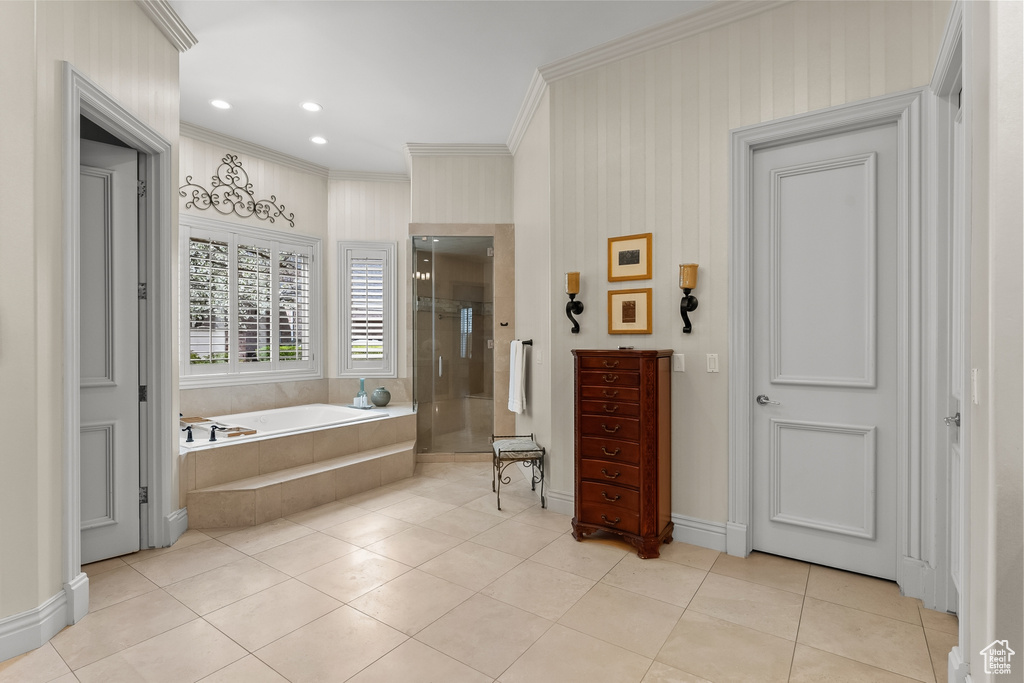 Bathroom with ornamental molding, separate shower and tub, and tile floors