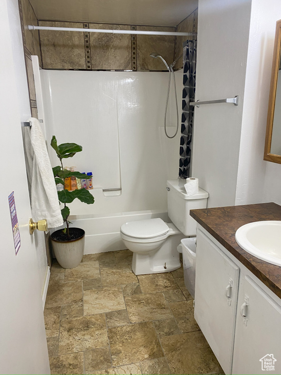 Full bathroom featuring tile flooring, toilet, large vanity, and shower / bathtub combination with curtain