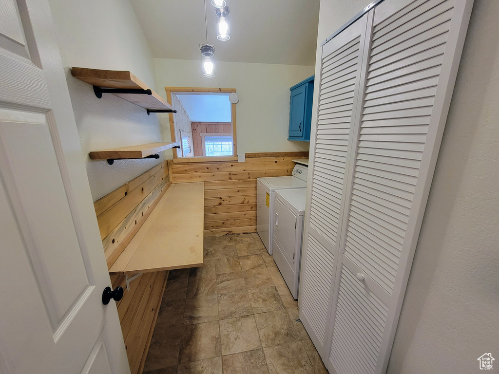 Laundry area with cabinets, light tile floors, and washer and clothes dryer