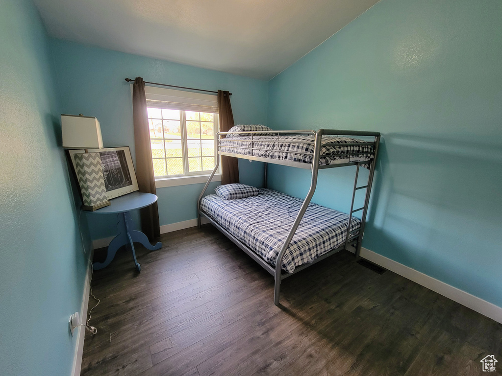 Bedroom with lofted ceiling and dark hardwood / wood-style floors