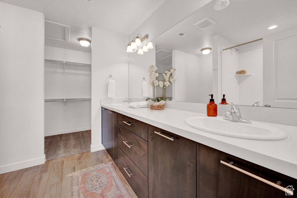 Bathroom featuring hardwood / wood-style floors, dual sinks, and oversized vanity