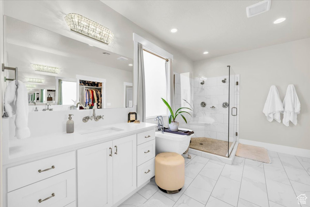 Bathroom with a shower with shower door, tile flooring, and vanity