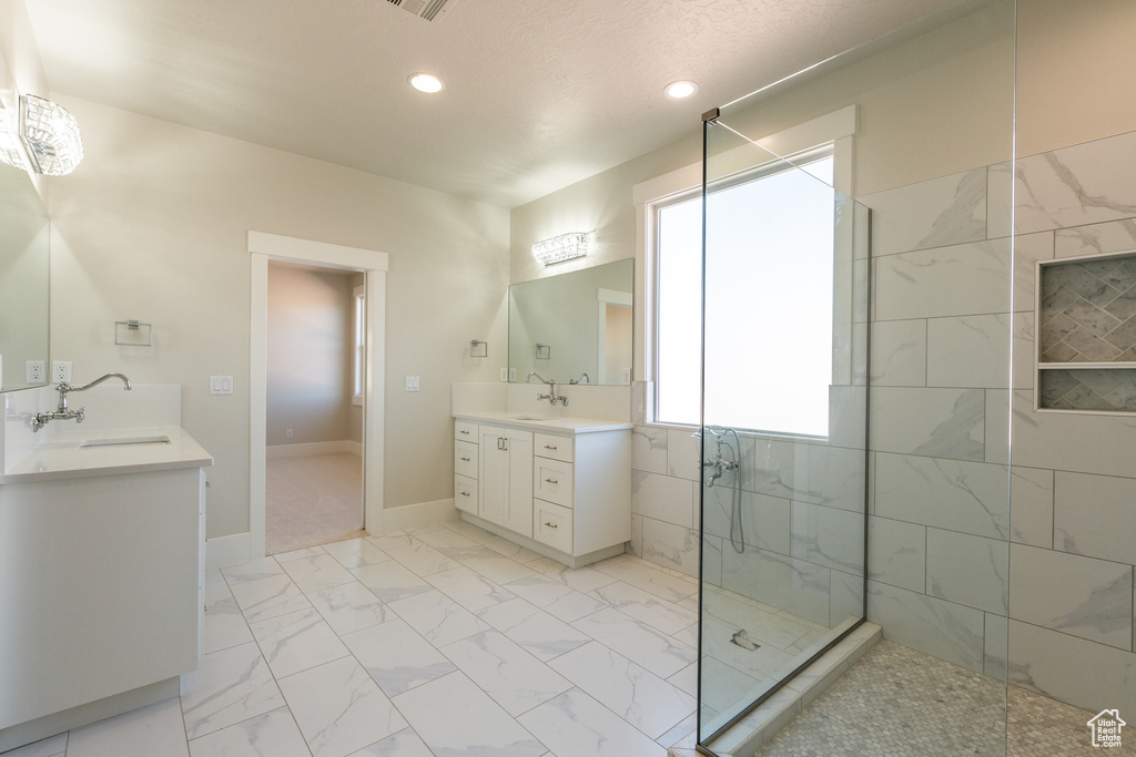 Bathroom with tile flooring, vanity, and an enclosed shower