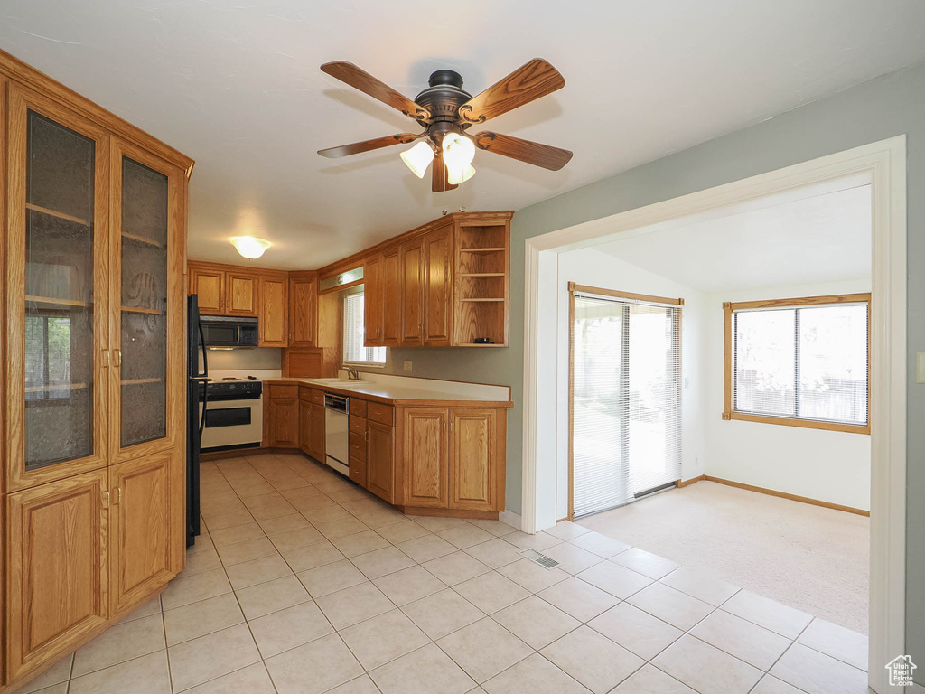 Kitchen featuring sink, white appliances, ceiling fan, and light tile flooring