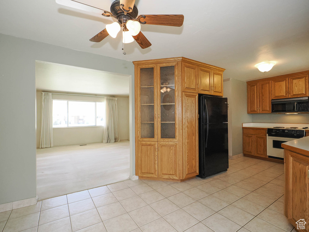 Kitchen featuring ceiling fan, light tile floors, and black appliances