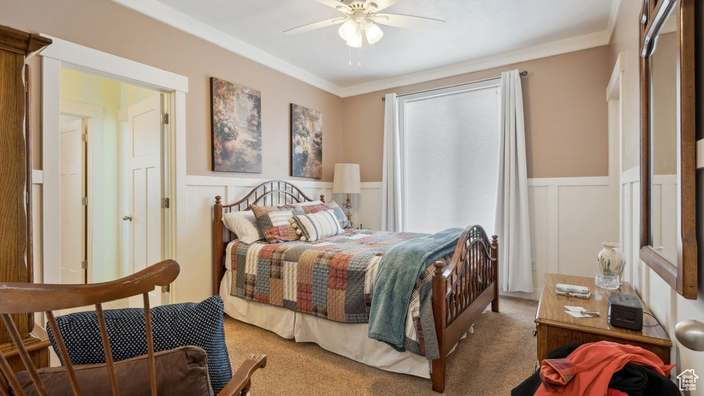 Bedroom with carpet floors, ceiling fan, and crown molding