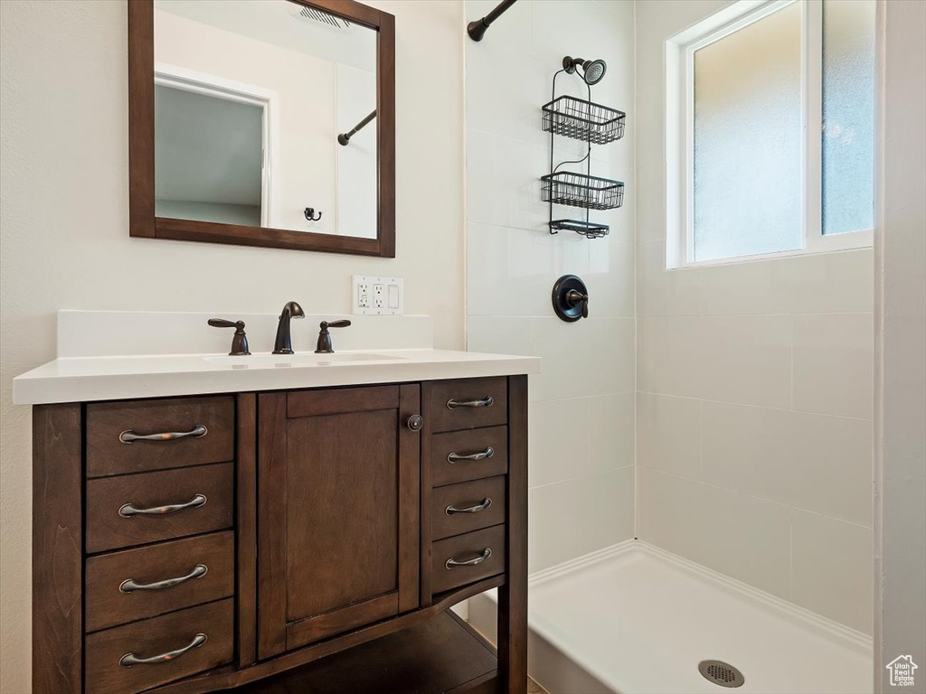 Bathroom featuring vanity and a tile shower