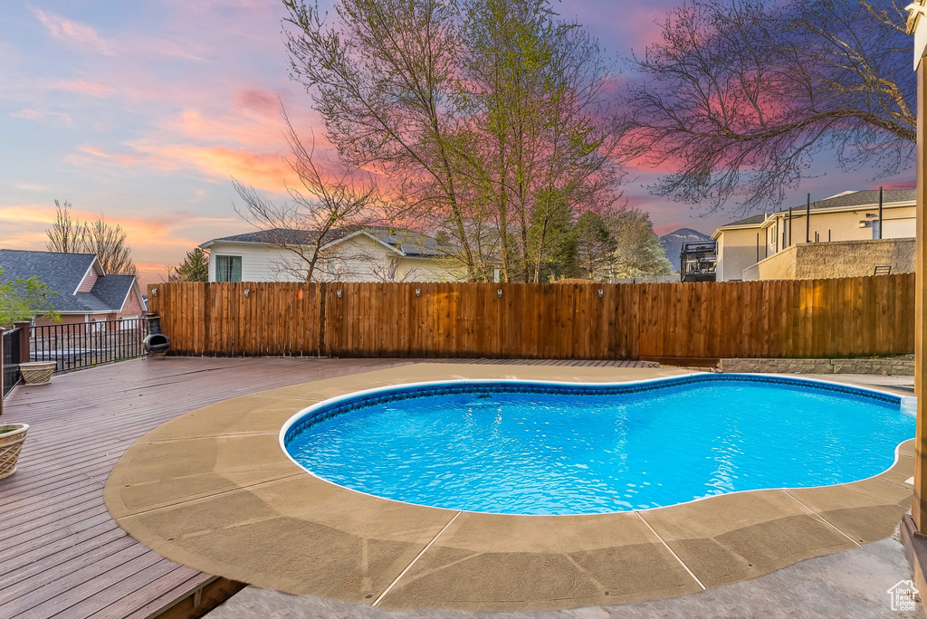 Pool at dusk with a wooden deck