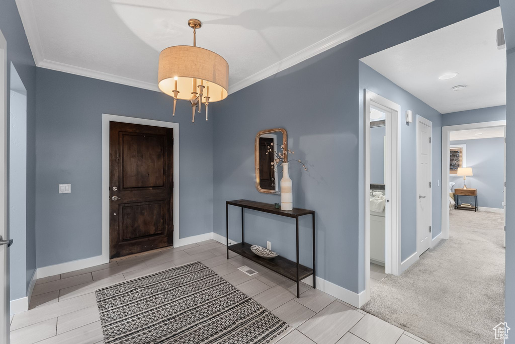 Carpeted entrance foyer with crown molding