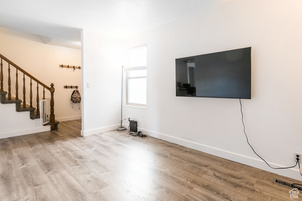 Unfurnished living room with light hardwood / wood-style flooring and radiator