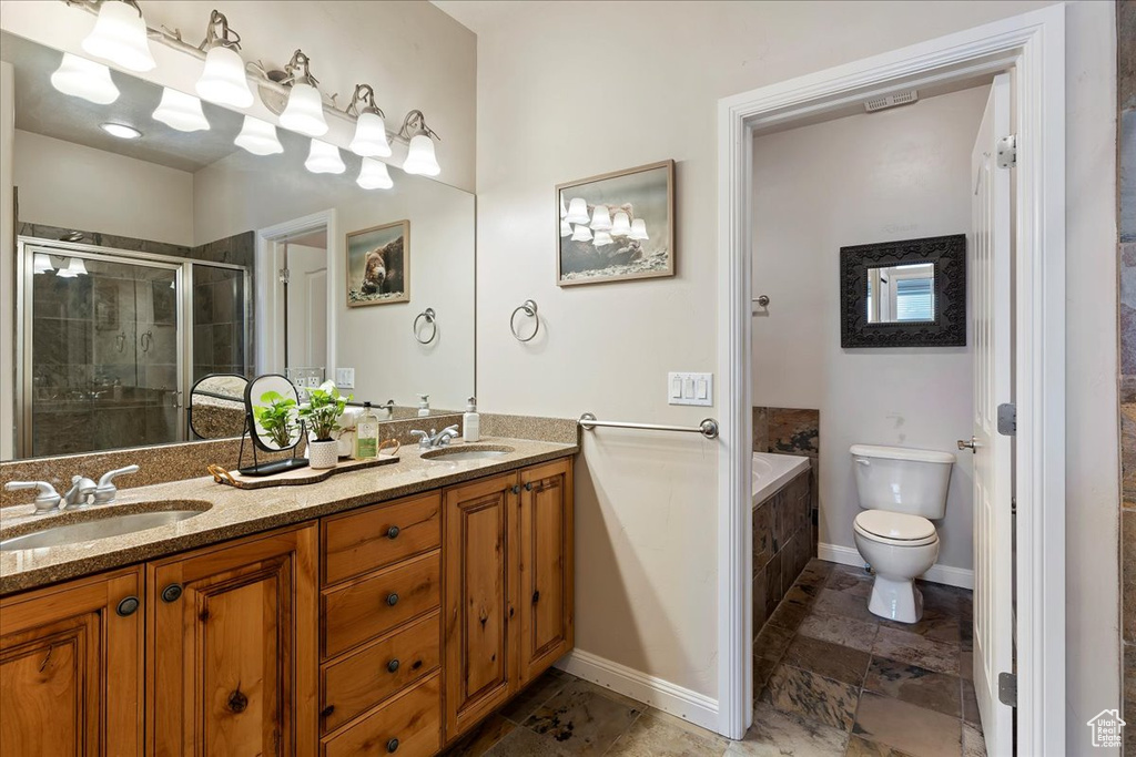 Full bathroom featuring oversized vanity, toilet, shower with separate bathtub, tile floors, and dual sinks