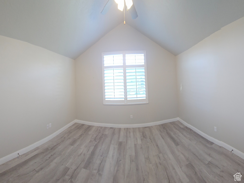Empty room featuring vaulted ceiling, light hardwood / wood-style floors, and ceiling fan