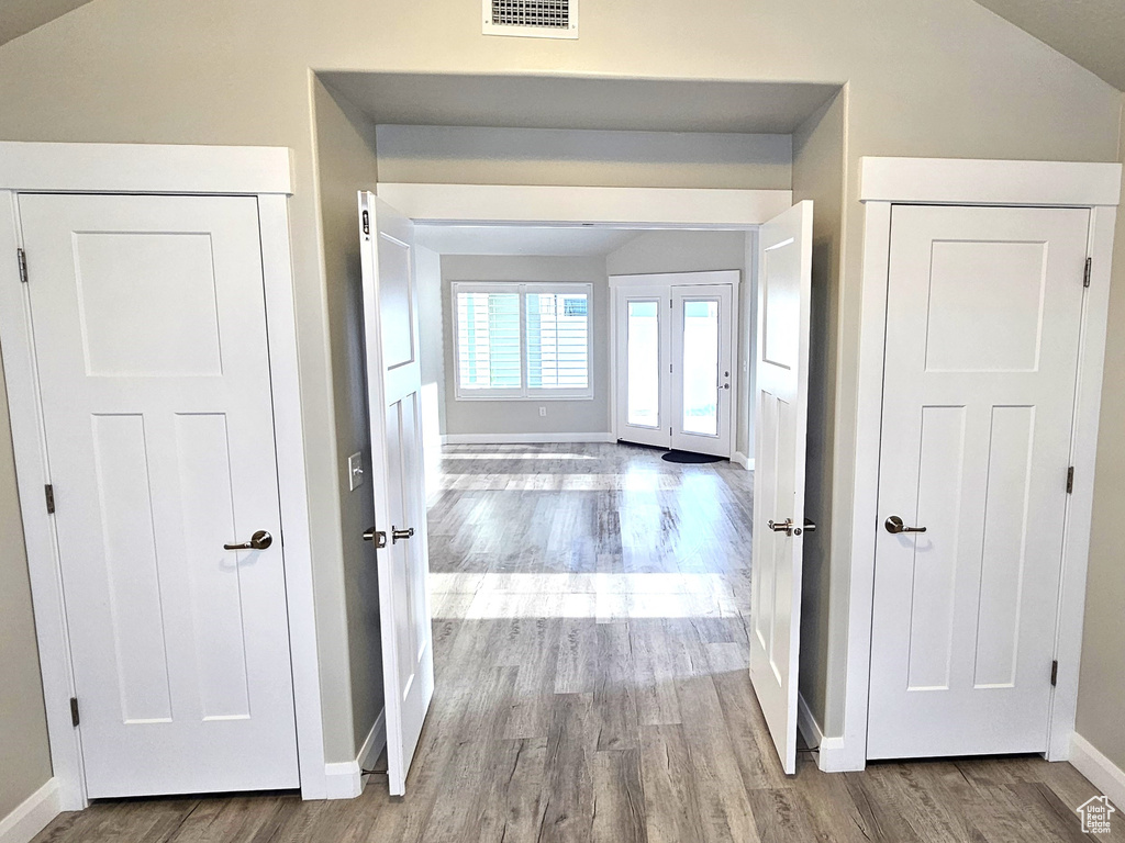 Hallway featuring light hardwood / wood-style flooring and vaulted ceiling