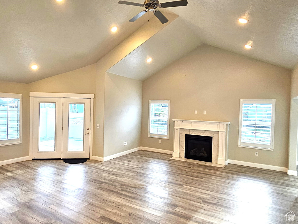 Unfurnished living room with high vaulted ceiling, ceiling fan, dark hardwood / wood-style floors, and a fireplace