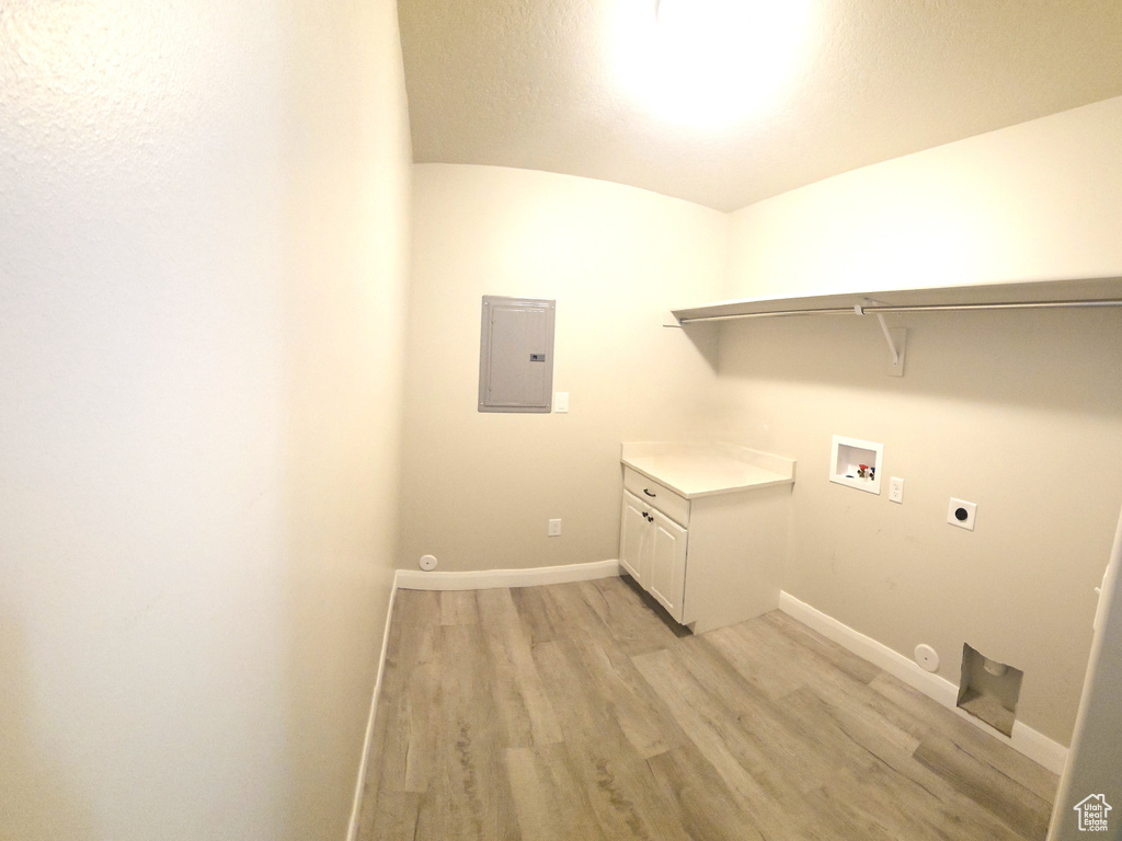 Washroom with gas dryer hookup, light hardwood / wood-style flooring, hookup for an electric dryer, washer hookup, and cabinets
