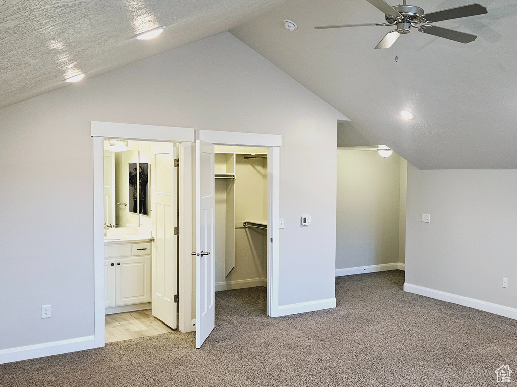 Additional living space featuring ceiling fan, a textured ceiling, vaulted ceiling, and light carpet