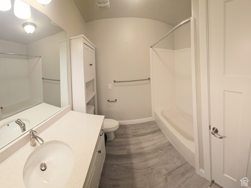 Full bathroom featuring hardwood / wood-style floors, shower / bathing tub combination, toilet, and large vanity