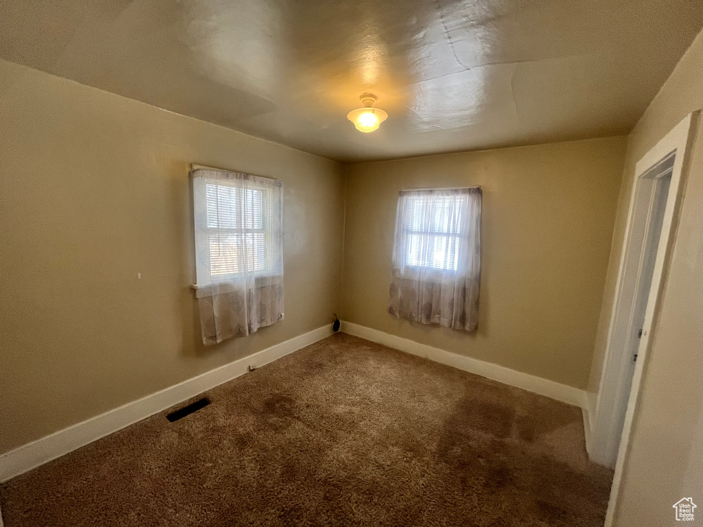 Unfurnished room with a healthy amount of sunlight and carpet floors