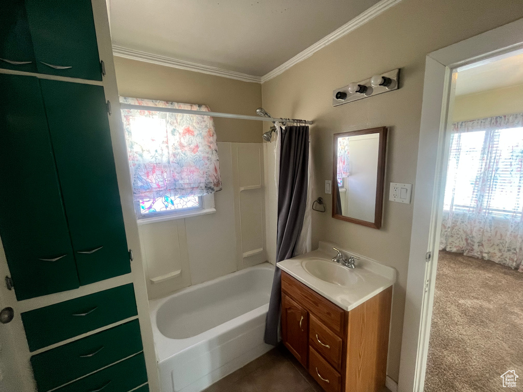 Bathroom with shower / bath combo, ornamental molding, and vanity with extensive cabinet space