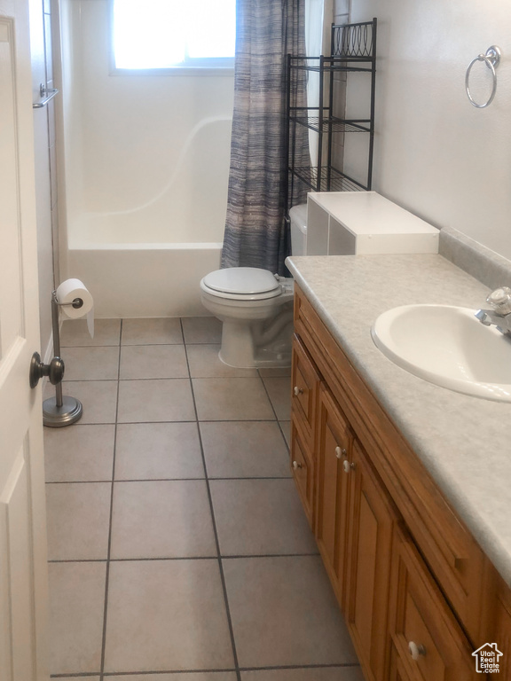 Full bathroom featuring toilet, tile flooring, vanity, and shower / bath combination with curtain