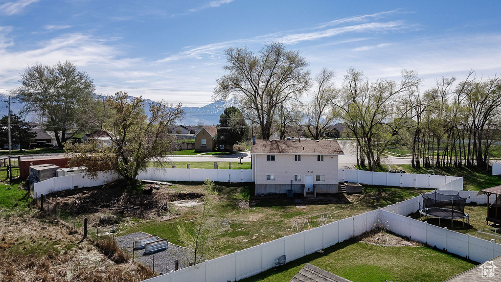 View of property's community featuring a mountain view, a trampoline, and a lawn