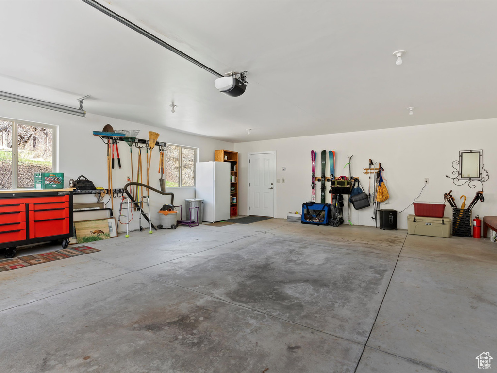 Garage with white fridge and a garage door opener