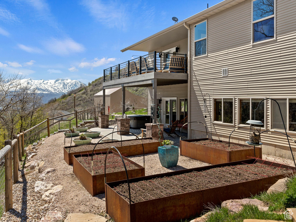 Exterior space featuring a patio area, a mountain view, french doors, and a balcony