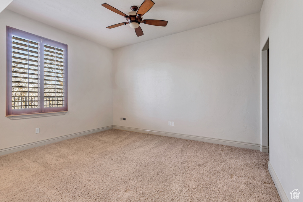 Spare room with ceiling fan and carpet