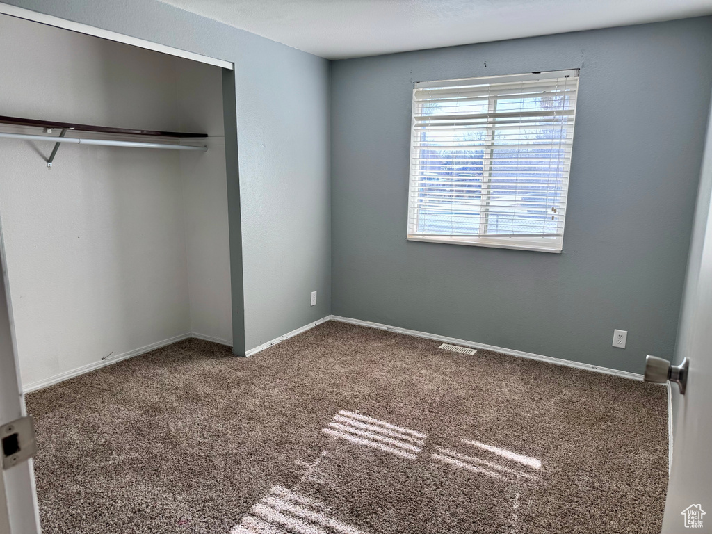 Unfurnished bedroom featuring carpet and a closet