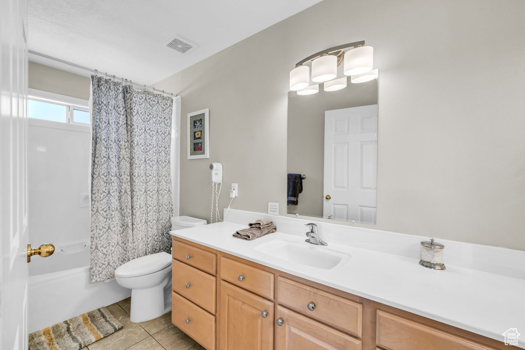 Full bathroom with toilet, tile floors, shower / tub combo with curtain, and large vanity