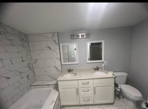 Bathroom featuring tile floors, large vanity, a bathing tub, dual sinks, and toilet