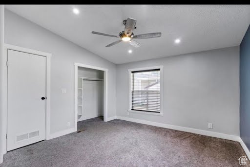 Unfurnished bedroom with vaulted ceiling, ceiling fan, and carpet