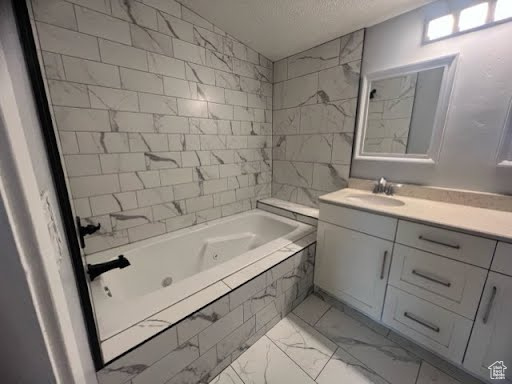 Bathroom featuring vanity with extensive cabinet space, tiled shower / bath, and tile flooring