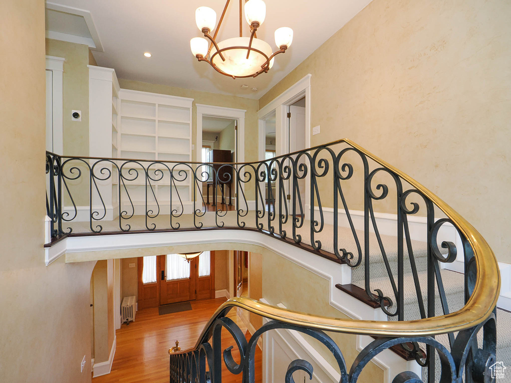 Stairs featuring a chandelier, radiator, french doors, and hardwood / wood-style flooring