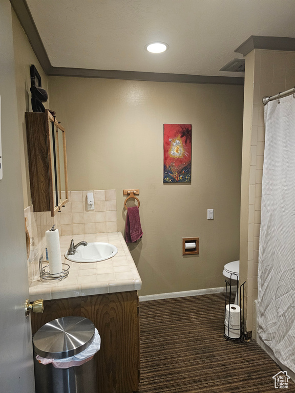 Bathroom featuring ornamental molding, tasteful backsplash, toilet, and vanity