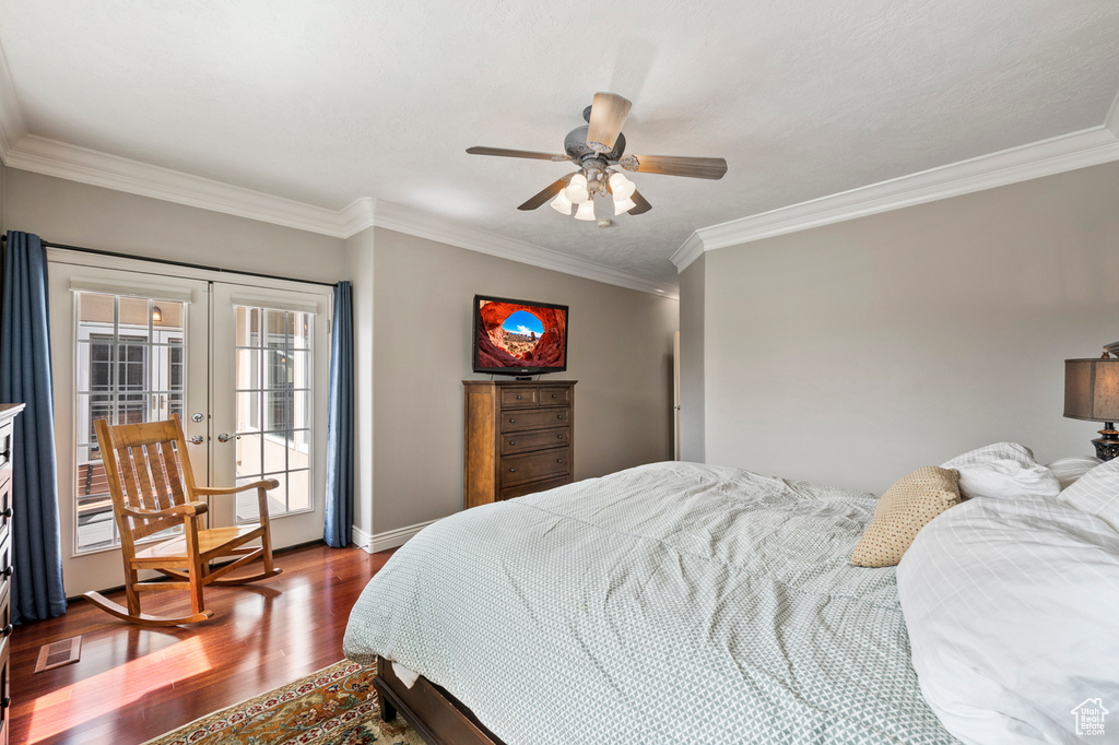 Bedroom with ornamental molding, wood-type flooring, ceiling fan, and french doors