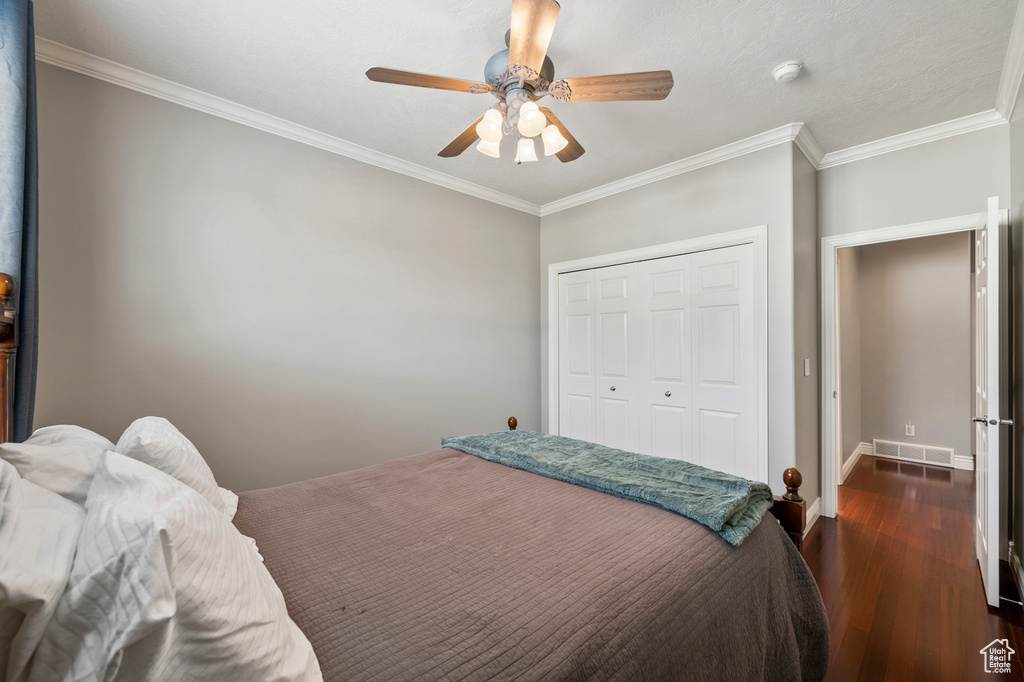 Bedroom featuring ornamental molding, a closet, ceiling fan, and dark hardwood / wood-style floors