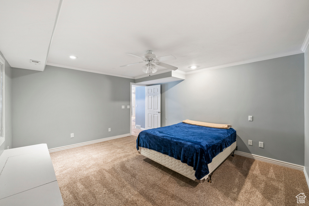 Bedroom with carpet floors, ceiling fan, and ornamental molding