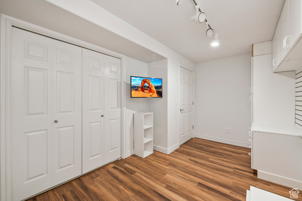 Interior space with rail lighting and hardwood / wood-style flooring